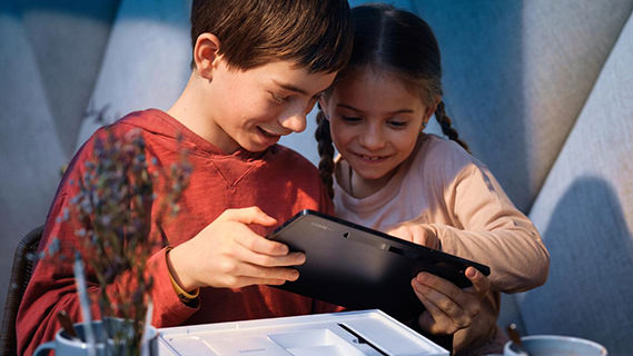 zwei Kinder spielen mit einem Tablet