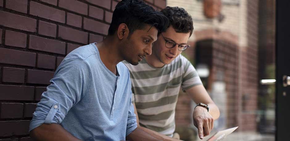 Zwei Männer am Laptop diskutieren
