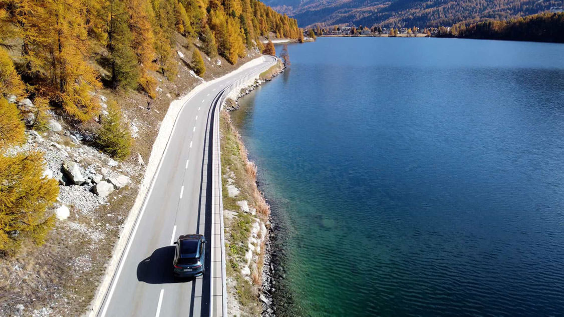 BMW roule sur la route le long d'un lac.