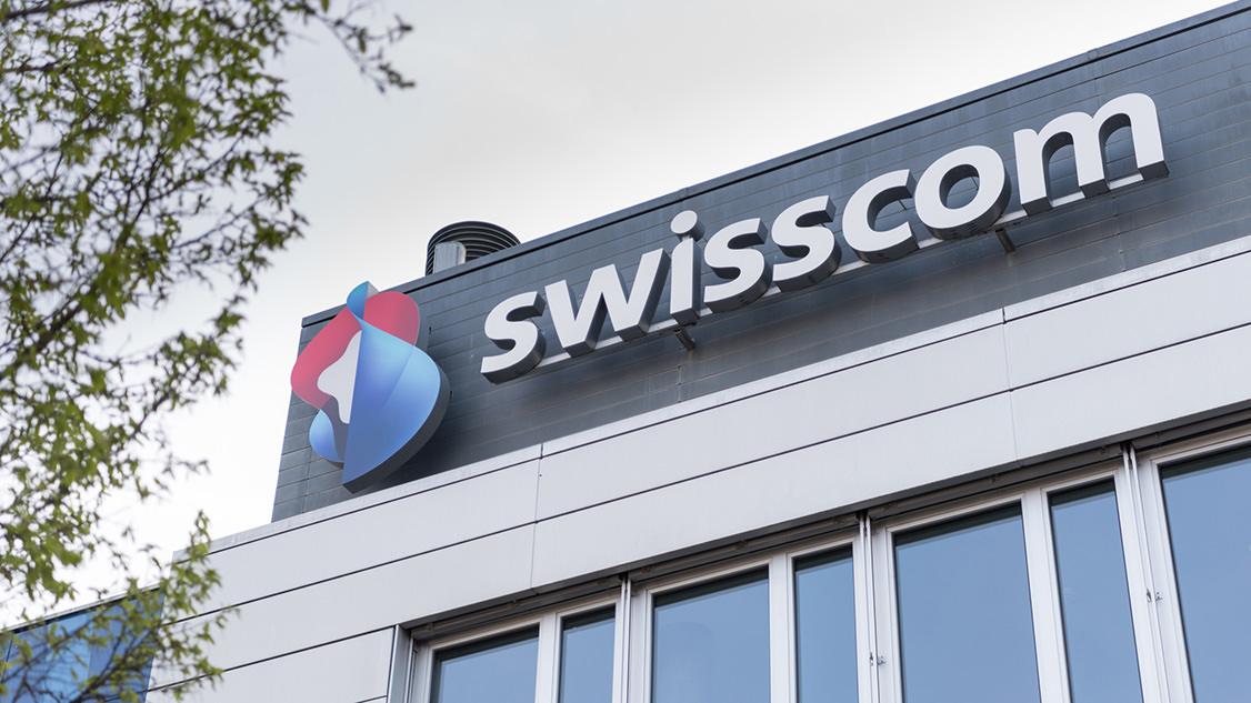 Inquadratura del logo Swisscom da vicino, sul tetto della sede principale di Worblaufen.