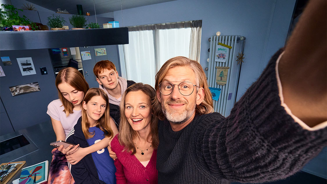 Una famiglia si scatta un selfie ed è visibilmente felice.