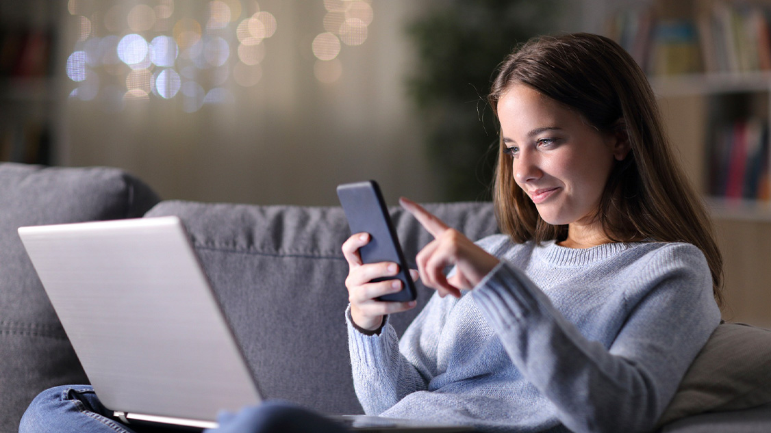 Una signora naviga in internet sul proprio smartphone.