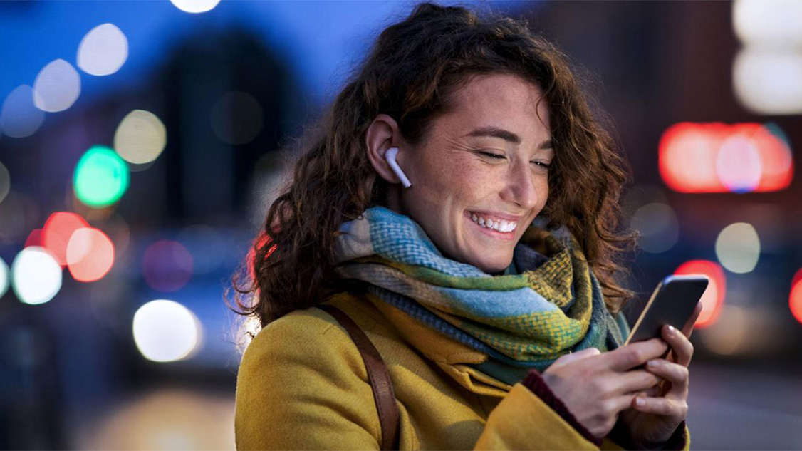 Une jeune femme heureuse utilise son téléphone portable.