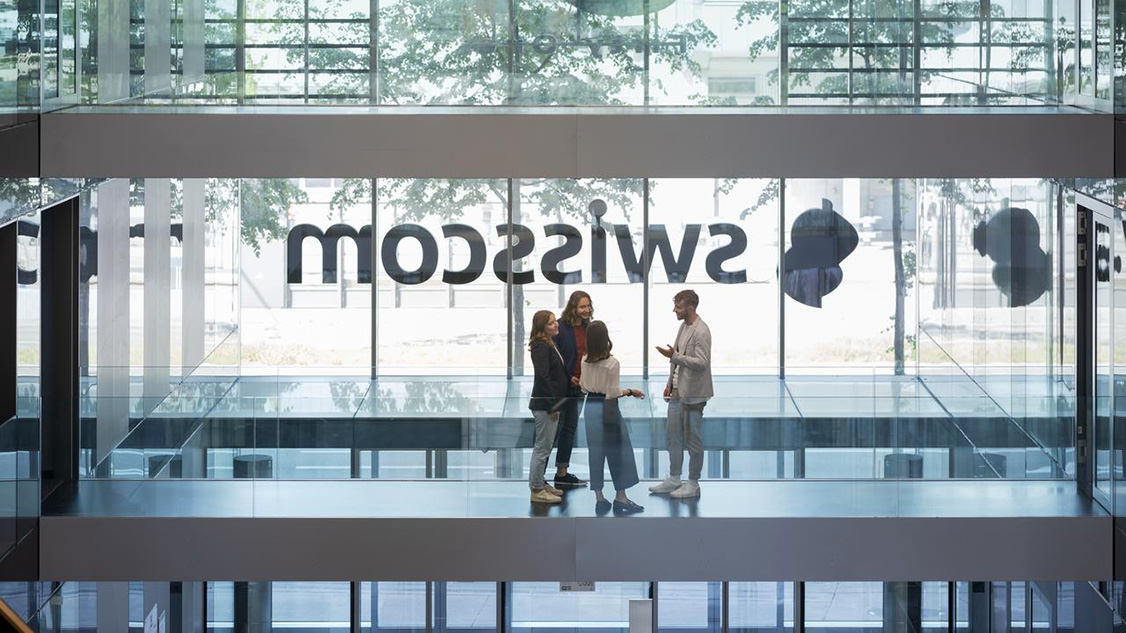 Des collaborateurs discutent dans un bâtiment Swisscom. 