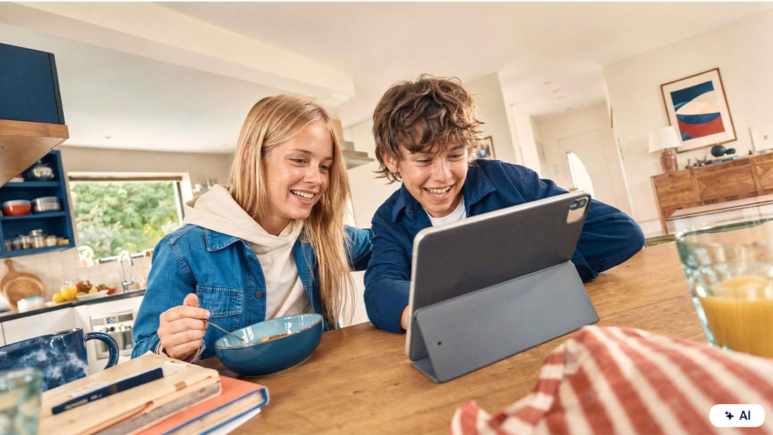 Deux enfants utilisent une tablette chez eux.