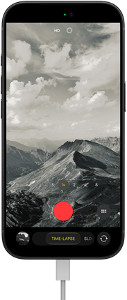 iPhone 18 Pro, face avant, affichant un paysage montagneux, avec le mode caméra incrusté en mode Accéléré, avec câble d’alimentation branché sur le port de charge