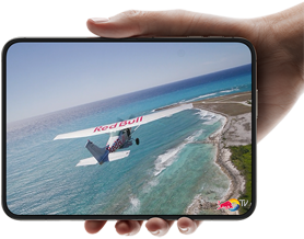 iPhone Duo, held with one hand, opened in horizontal orientation, fully unfolded, interior screen displays a photo of a plane flying over a beach.