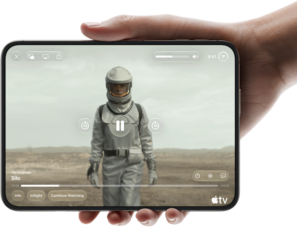 iPhone Duo, tenu à une main, ouvert en position horizontale, entièrement déplié, l’écran interne affichant la série Apple TV « Silo »