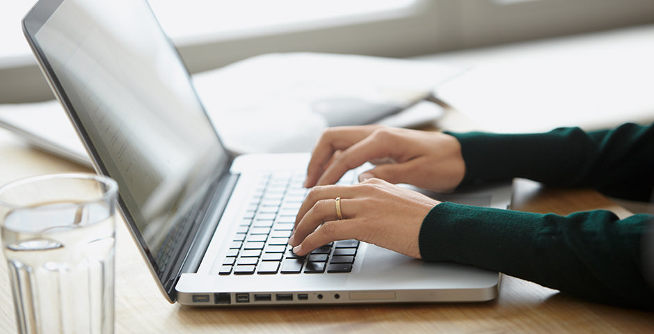 Hände tippen auf die Tastatur eines Laptops