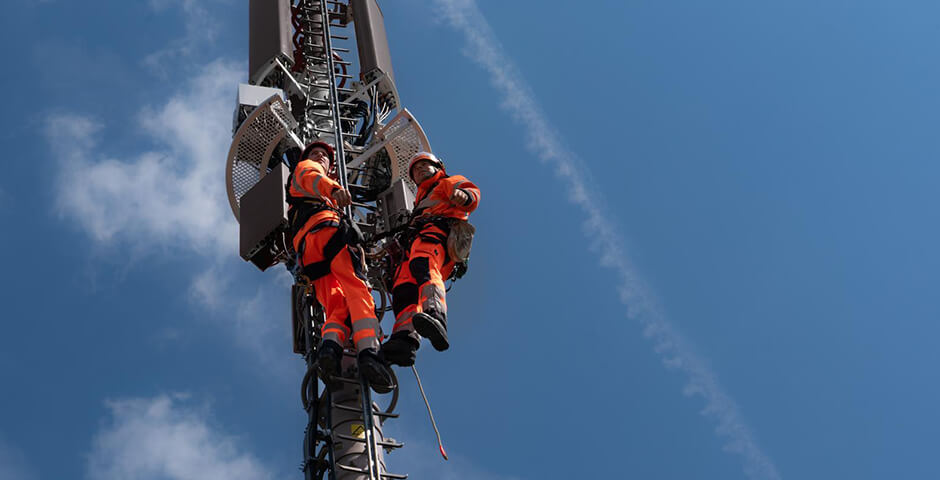 Arbeiter auf Mobilfunk-Antenne