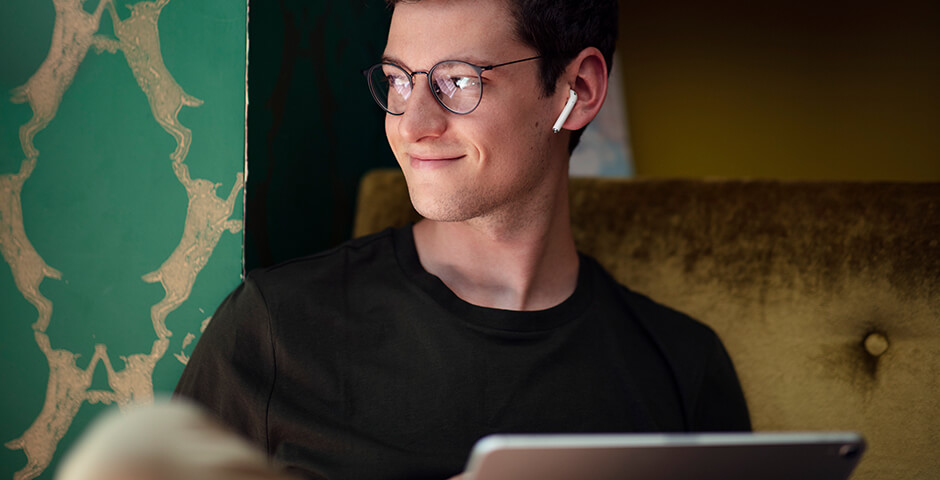 Mann jung mit inEar und Laptop