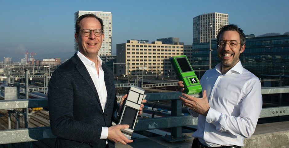 Two men on railway bridge with IoT devices in their hands