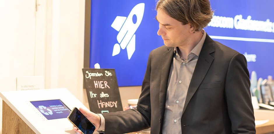 A man puts his used phone in a collection box in the Swisscom shop.